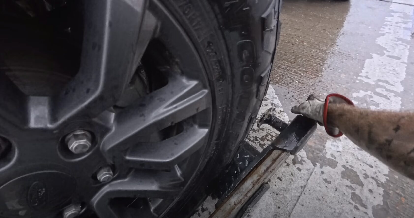 Close-up of vehicle wheel and towing equipment during breakdown