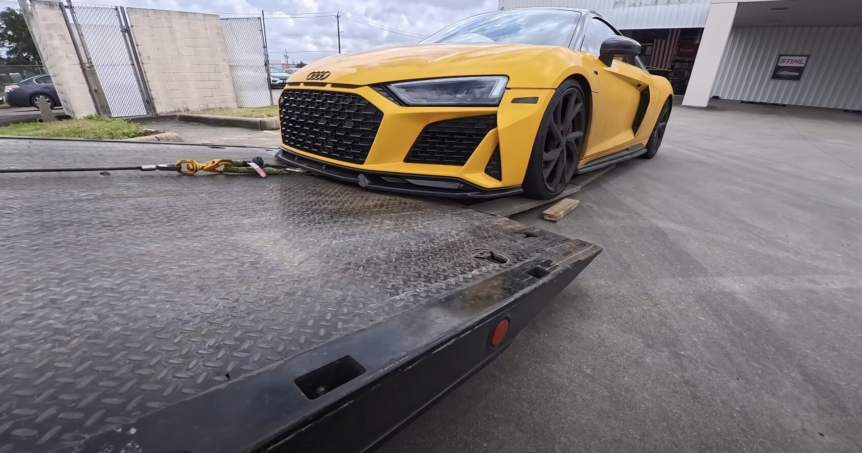 Luxury sports car being loaded onto flatbed tow truck