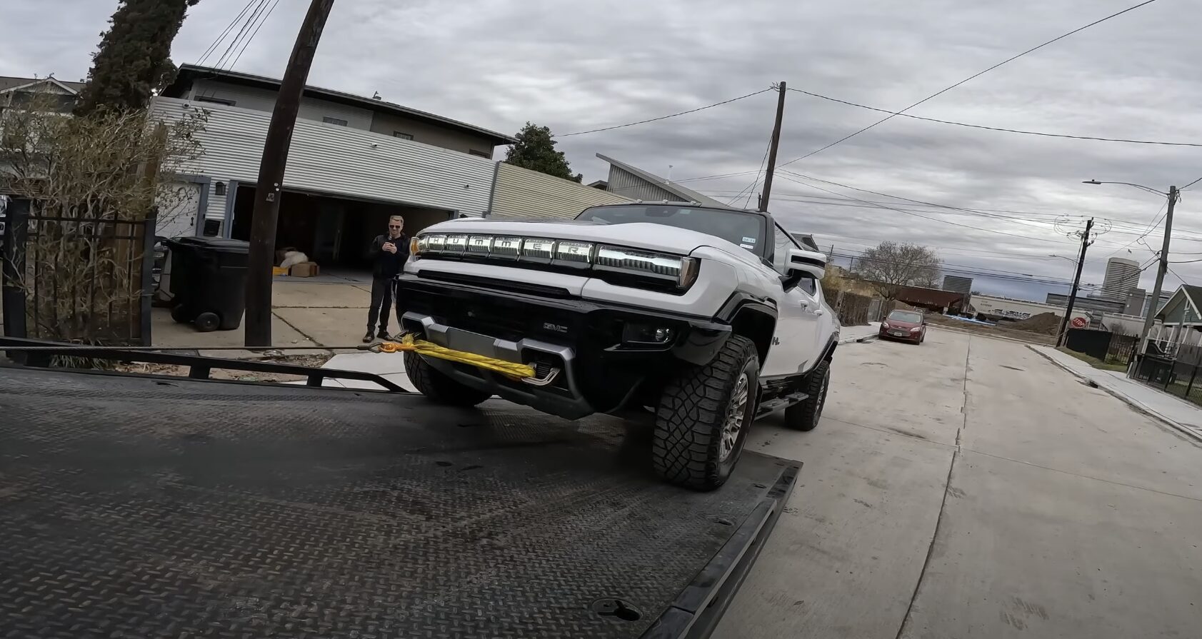 Professional tow truck loading a white pickup truck